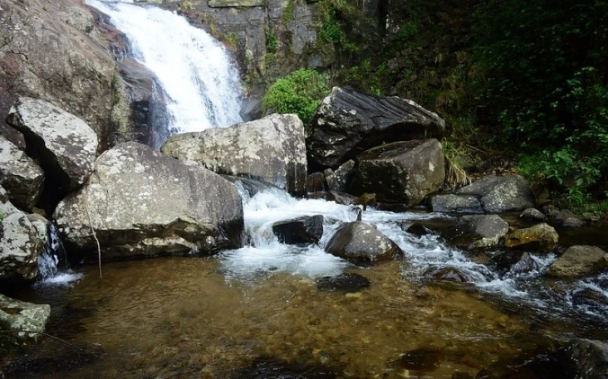 Natural waterfall in Belihuloya surrounded by forest and rock formations in Sri Lanka