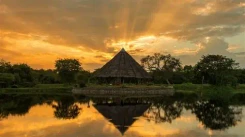 Traditional lakeside eco lodge surrounded by nature at sunset in rural Sri Lanka