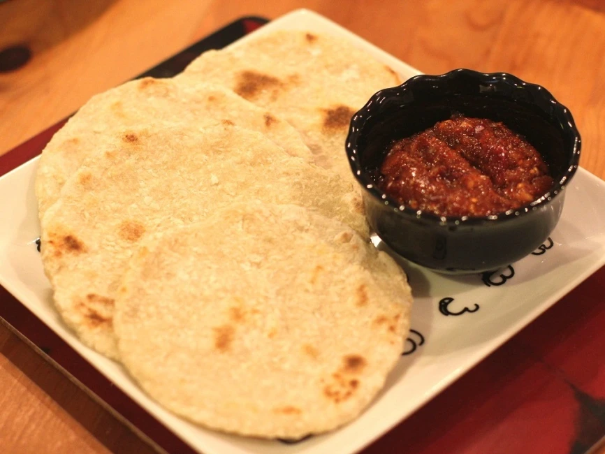 Traditional Sri Lankan coconut roti served with spicy lunu miris sambol for breakfast.