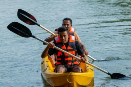 Tourists kayaking on a scenic lake during an outdoor adventure experience in Sri Lanka.