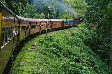 Sri Lankan passenger train travelling through lush green hills on the scenic Colombo to Kandy railway route.
