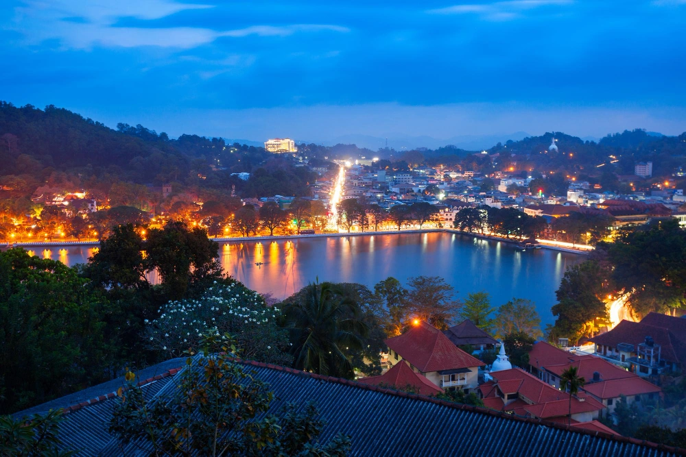 Panoramic evening view of Kandy city and illuminated Kandy Lake surrounded by hills in Sri Lanka’s central highlands.