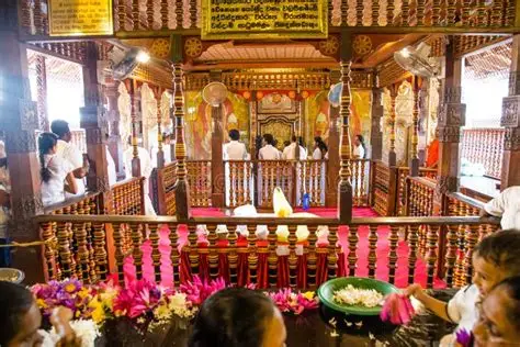 Devotees making traditional flower offerings inside the Temple of the Sacred Tooth Relic in Kandy, Sri Lanka.