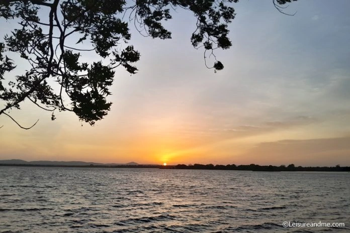 Golden sunset over the calm waters of Parakrama Samudra reservoir in Polonnaruwa, Sri Lanka.