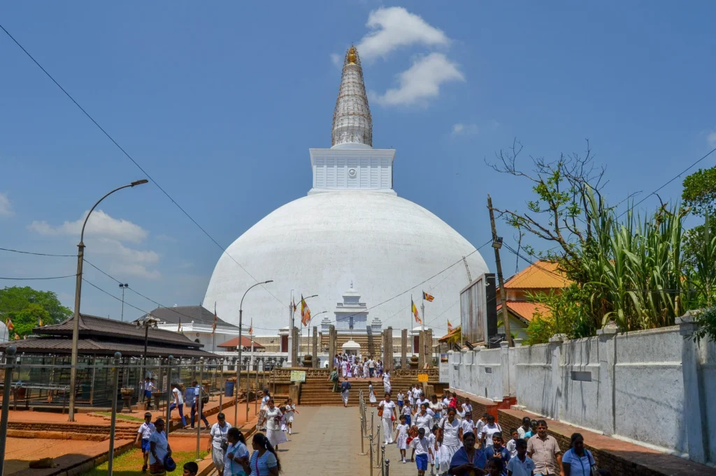 Buddhist pilgrims walking toward the sacred Ruwanwelisaya stupa in Anuradhapura, Sri Lanka.