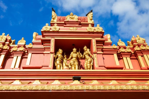 Ornate red and gold gopuram decorated with Hindu deity sculptures at Seetha Amman Temple in Sri Lanka.