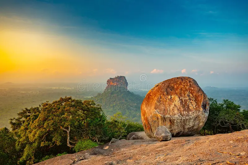 Scenic view of Sigiriya Rock Fortress from Pidurangala Rock during golden light in Sri Lanka.