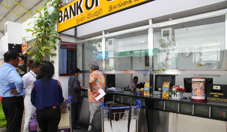 Travellers using a currency exchange counter in Sri Lanka to exchange foreign money for local currency.